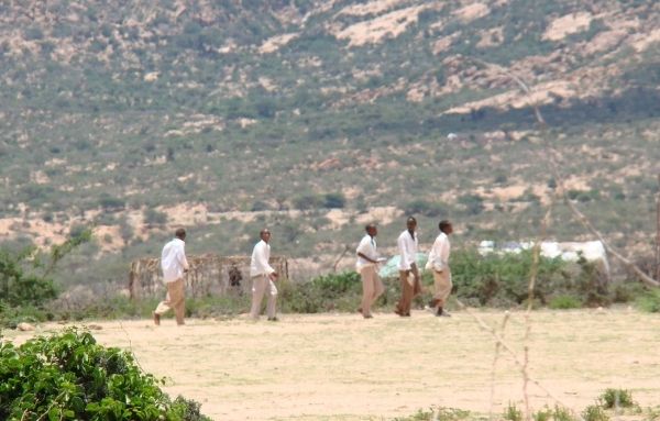Eine Gruppe aus fünf Schülern beim Sportunterricht draußen auf dem Feld vor einem Berg