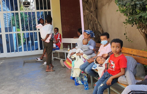 Eltern warten mit ihren Kindern auf den Arm im Außenbereich einer Kinderklink
