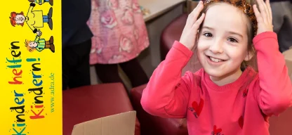 Mädchen schaut lächelnd mit Blumenkrone in die Kamera