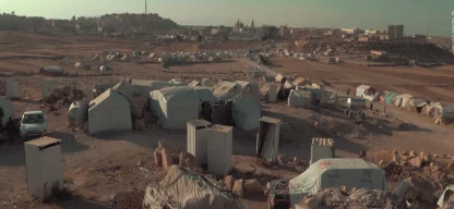 Humanitäre Katastrophe im Jemen - Landschaft aus Zelten. Im Hintergrund sieht man Gebäude und eine Moschee.