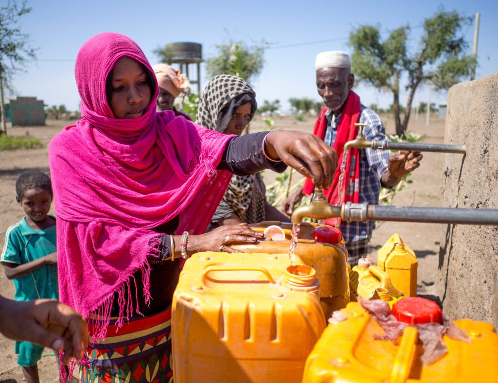Äthiopische Frau füllt Wasser in Kanister