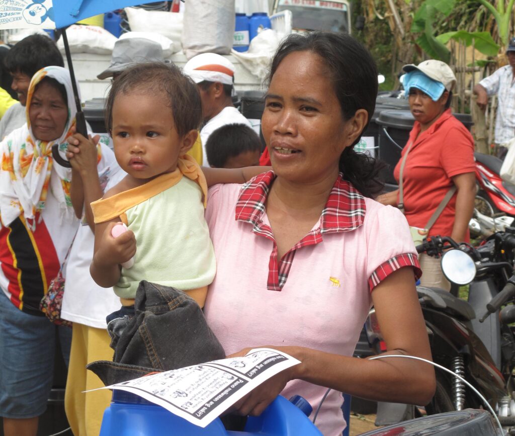 Überlebende des Taifuns Yolanda bei einer ADRA-Verteilung von Wasserbehältern auf den Philippinen