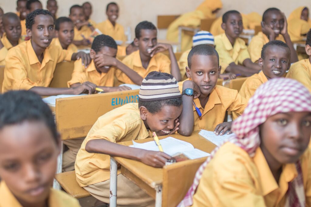 Eine Schulklasse bestehend aus Jungen in gelber Schuluniform sitzt im Klassenraum