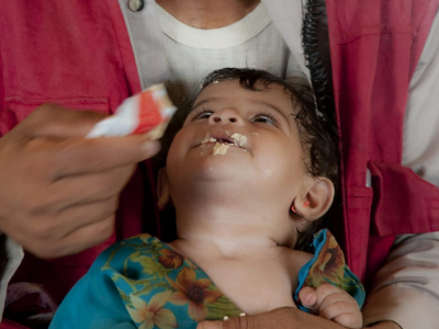 Ein Kleinkind bekommt Notnahrung in Form eines Erdnussriegels