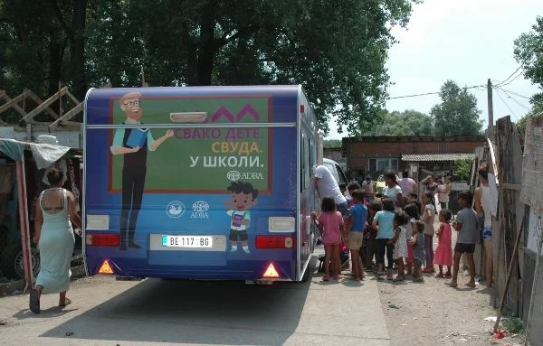 Viele junge Schüler warten aufgeregt darauf, die mobile Schule von innen zu sehen