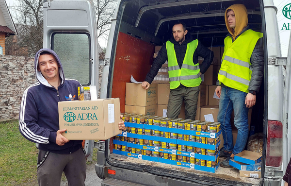 Drei ADRA-Helfer aus der Ukraine entladen einen Transporter, welcher für die Lebensmittelverteilung zuständig ist.