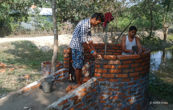 Zwei Bewohner helfen bei Brunnenbau in Indien