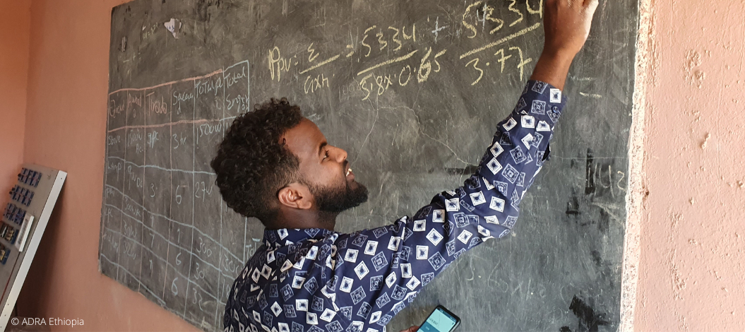 Ein jugendlicher in Äthiopien rechnet eine Matheaufgabe an einer Tafel in der Schule.