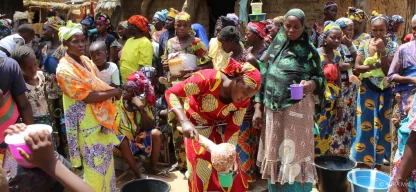 Frauen und Kinder in Togo kochen gemeinsam im Freien mit traditionellen Methoden