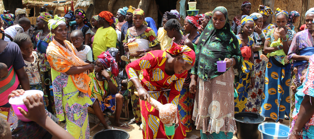 Frauen und Kinder in Togo kochen gemeinsam im Freien mit traditionellen Methoden