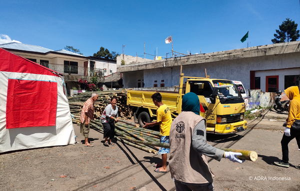 ADRA Mitarbeiter und freiwillige Helfer transportieren Baumaterialien, wie Bambus zur Errichtung von Notunterkünften und zur Sanierung von beschädigten Häusern im Südwesten von Indonesien Cianjur, nach einem Erdbeben.