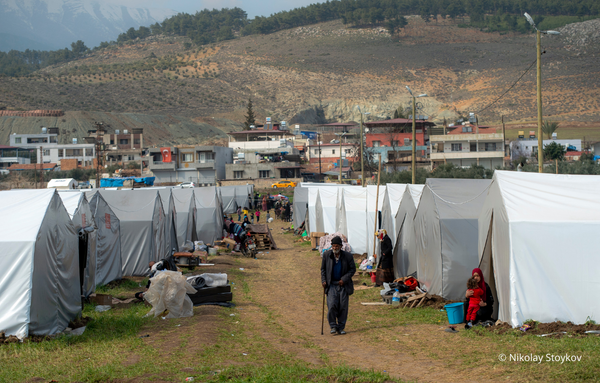 Menschen stehen vor den aufgestellten Zelten in der Türkei, nachdem ihre Häuser und Wohnung durch ein Erdbeben zerstört wurden.
