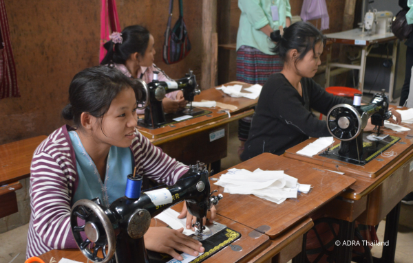 Drei fleißige Näherinnen aus Thailand bei der Arbeit an ihren Nähmaschinen.