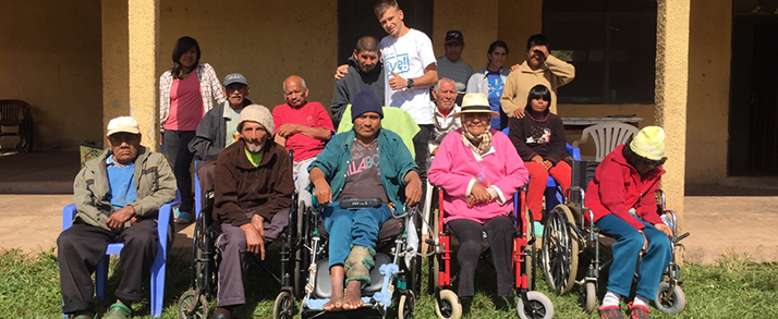 Florian steht in der Mitte einer Gruppe von Menschen mit körperlichen Beeinträchtigungen in Bolivien.