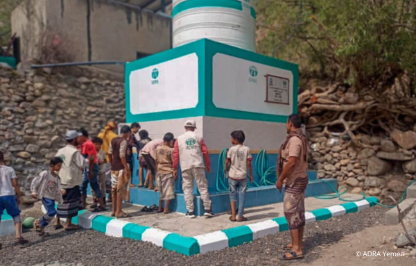 Kinder und Erwachsene aus dem Jemen waschen sich an einer Wasseranlage, eine wichtige Ressource für Sauberkeit und Hygiene
