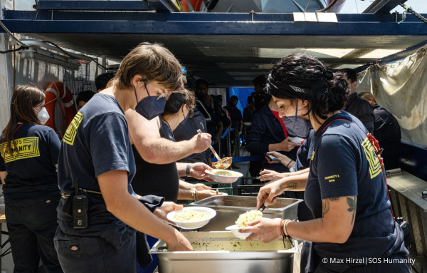 Engagierte Helfer und Mitarbeiter von SOS Humanity bereiten herzhaftes Essen für die ankommenden Seenotflüchtlinge vor.