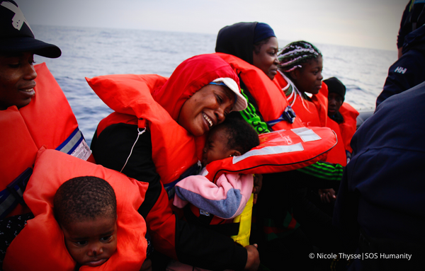 Geflüchtete Menschen auf dem Mittelmeer, erleichtert nach ihrer Rettung. Eine Mutter umarmt voller Freude und Erleichterung ihr weinendes Kind. © Nicole Thysse_SOS Humanity