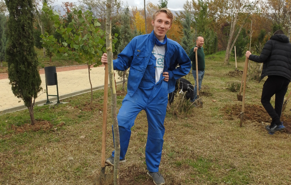 Ein Freiwilliger posiert stolz neben drei anderen Personen nach dem Pflanzen von Bäumen während seines Freiwilligen Sozialen Jahres in Albanien