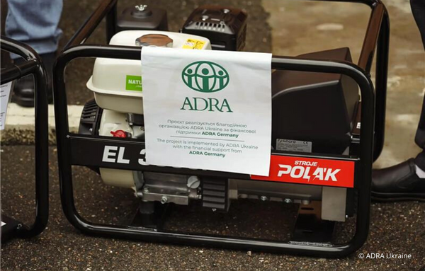 Ein Bild eines Stromgenerators mit einem großen ADRA-Logo und einem Zettel darauf, der besagt: "Das Projekt wird von ADRA Ukraine mit finanzieller Unterstützung von ADRA Deutschland umgesetzt. Ihre Unterstützung für notleidende Menschen in der Ukraine.