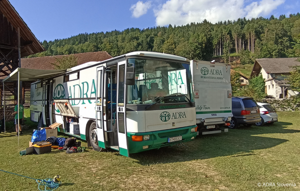 ADRA-Bus und -LKW bei Wiederaufbau in Slowenien nach Flutkatastrophe. Fahrzeuge transportieren Werkzeuge und Materialien für den Wiederaufbau nach der Naturkatastrophe.