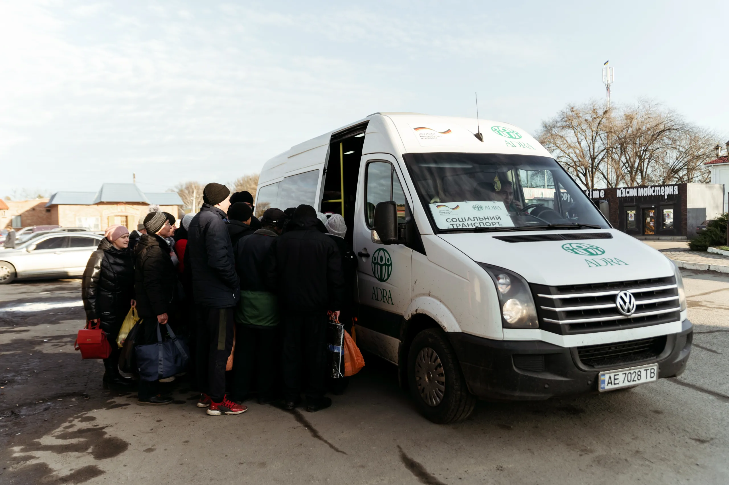 Eine Gruppe von Menschen, die in einem Transportfahrzeug einsteigen will, um evakuiert zu werden.
