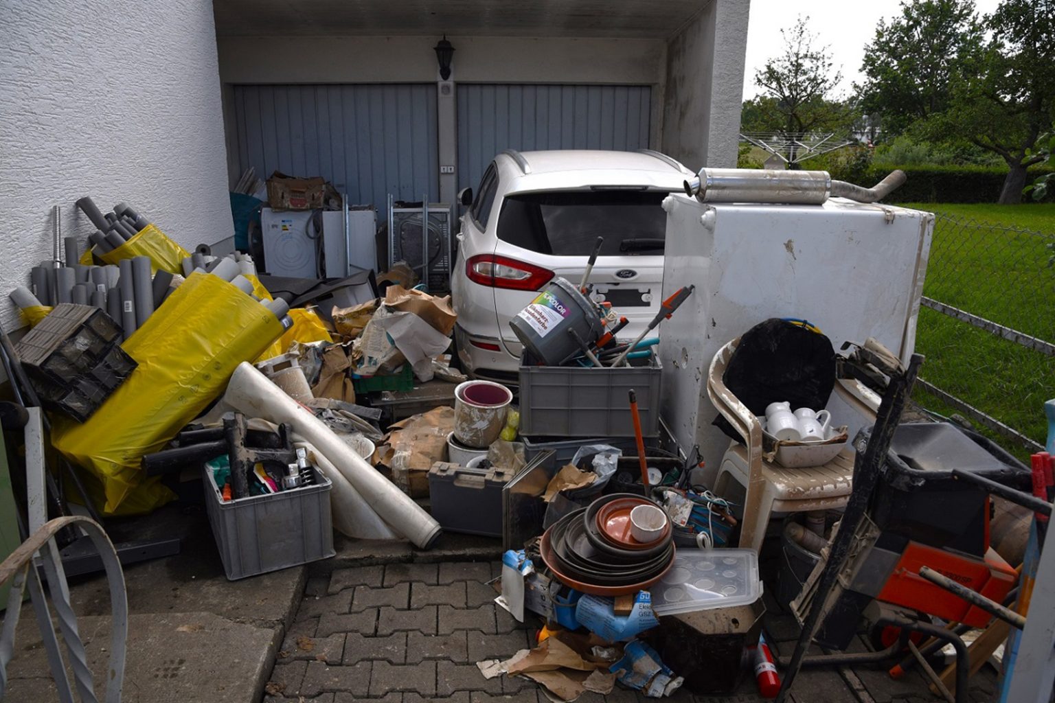 Ein überflutetes Wohngebiet in Offingen zeigt die Folgen des Hochwassers: Keller und Wohnräume müssen geräumt werden, während schrottreife Autos im Wasser stehen. (Foto: ADRA Deutschland e.V./Andreas Lerg)