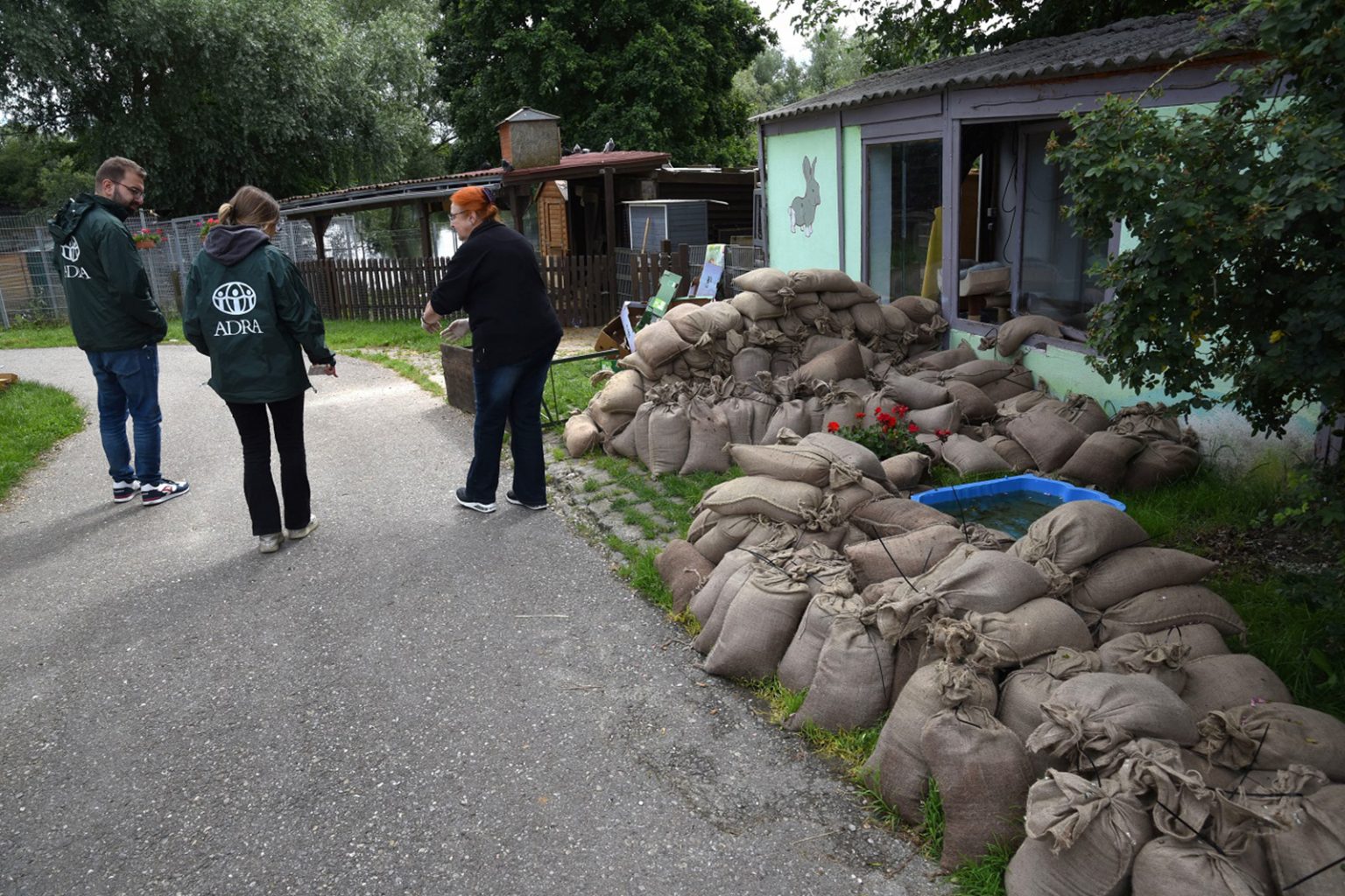 Ehrenamtliche Helfer errichteten einen Wall aus Sandsäcken, um Teile eines Tierheims vor der Überflutung zu schützen. Tiefer gelegene Gehege, wie für Ziegen oder verletzte Störche, wurden jedoch schwer beschädigt. Alle Tiere konnten rechtzeitig evakuiert und in anderen Tierheimen untergebracht werden. (Foto: ADRA Deutschland e.V./Andreas Lerg)