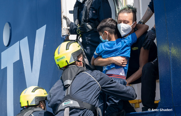 Helfer tragen einen kleinen Jungen auf das Schiff der SOS Humanitary 1.