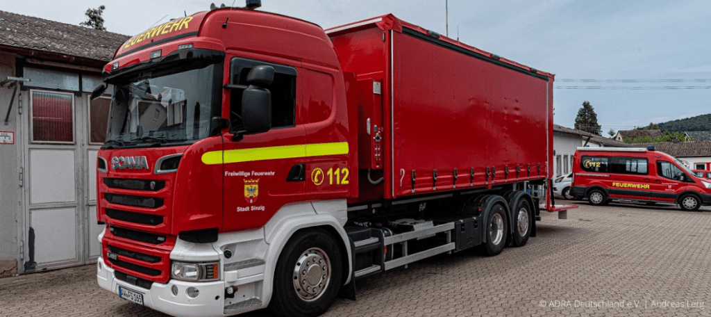 Feuerwehrfahrzeug von Scania mit Blaulicht und Funkgeräten, individuell angepasster Abrollbehälter. (Foto: ADRA Deutschland e.V. Andreas Lerg)