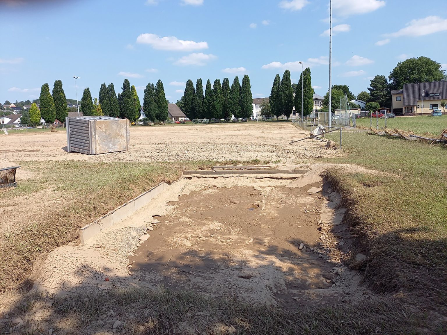 Foto eines Materialcontainers, der durch die Flut vom Fundament gerissen wurde und auf das Spielfeld gespült wurde, aufgenommen vom RSV Arloff-Kirspenich e.V.