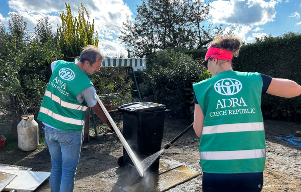 ADRA-Helfer aus Tschechien reinigen gemeinsam mit Freiwilligen Straßen und Mülltonnen , die nach dem Hochwasser in Mittel- und Osteuropa von Schlamm und Trümmern bedeckt sind.