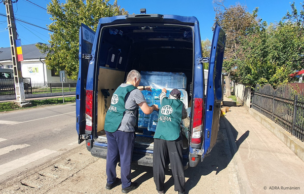 Freiwillige entladen Hilfsgüter aus einem Transporter in einer vom Hochwasser betroffenen Region. Die Pakete werden direkt an die betroffenen Familien verteilt, um dringend benötigte Unterstützung zu leisten.