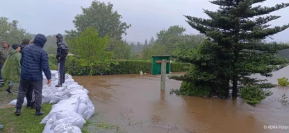 Überflutete Straße mit ADRA-Helfern im Einsatz.