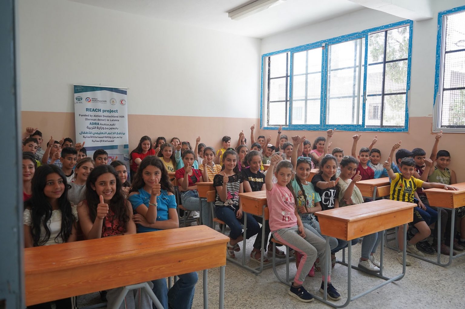 Kinder in einer Schulklasse melden sich