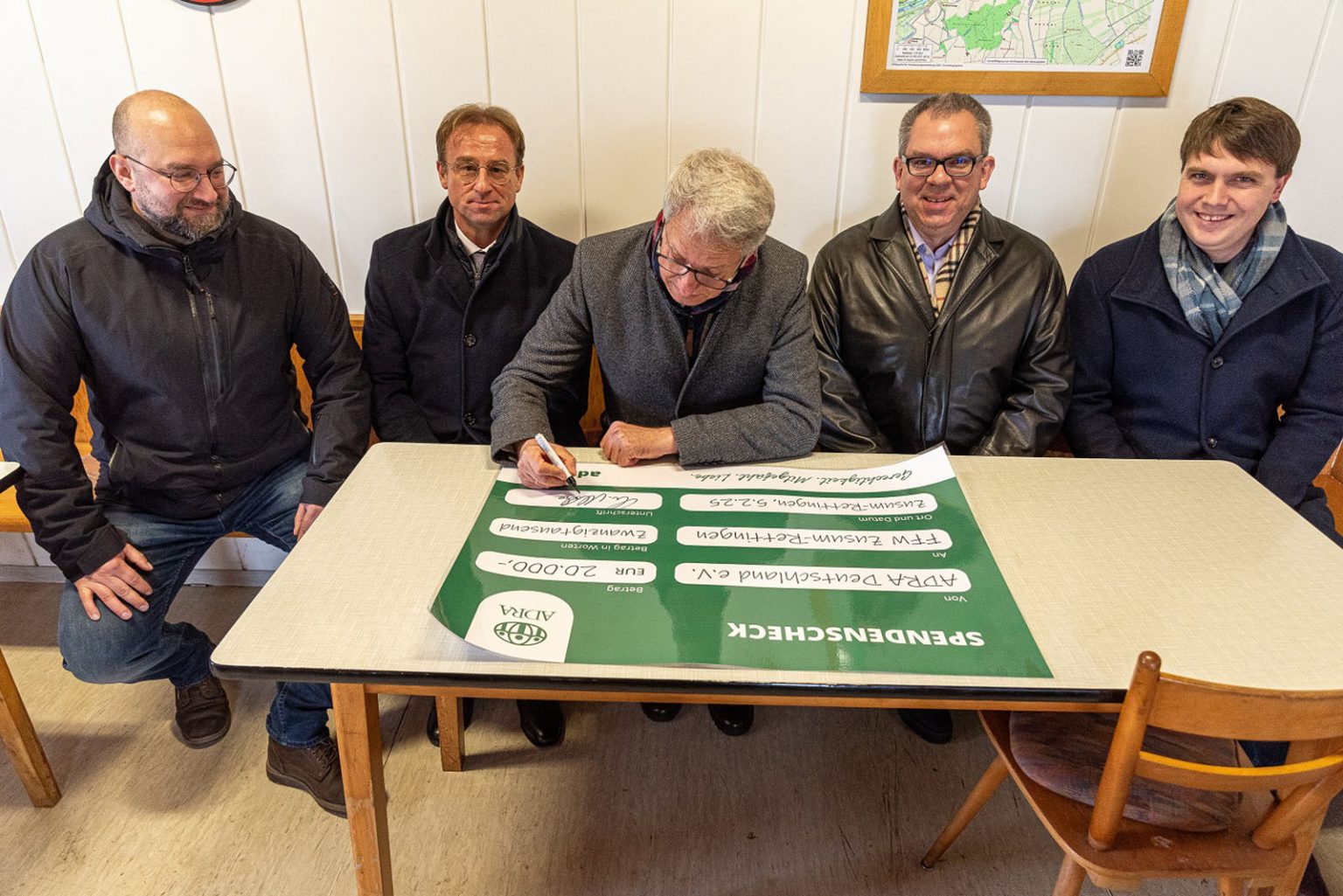 Christian Molke, Vorstand von ADRA Deutschland e.V., unterschreibt Scheck für Freiwillige Feuerwehr Zusum Rettingen. FOTO: ADRA Deutschland e.V./Andreas Lerg
