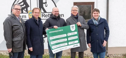 Christian Molke von ADRA Deutschland übergibt Spendenscheck über 20.000 Euro an Feuerwehrkommandant Timo Bablok, umringt von drei Kollegen.