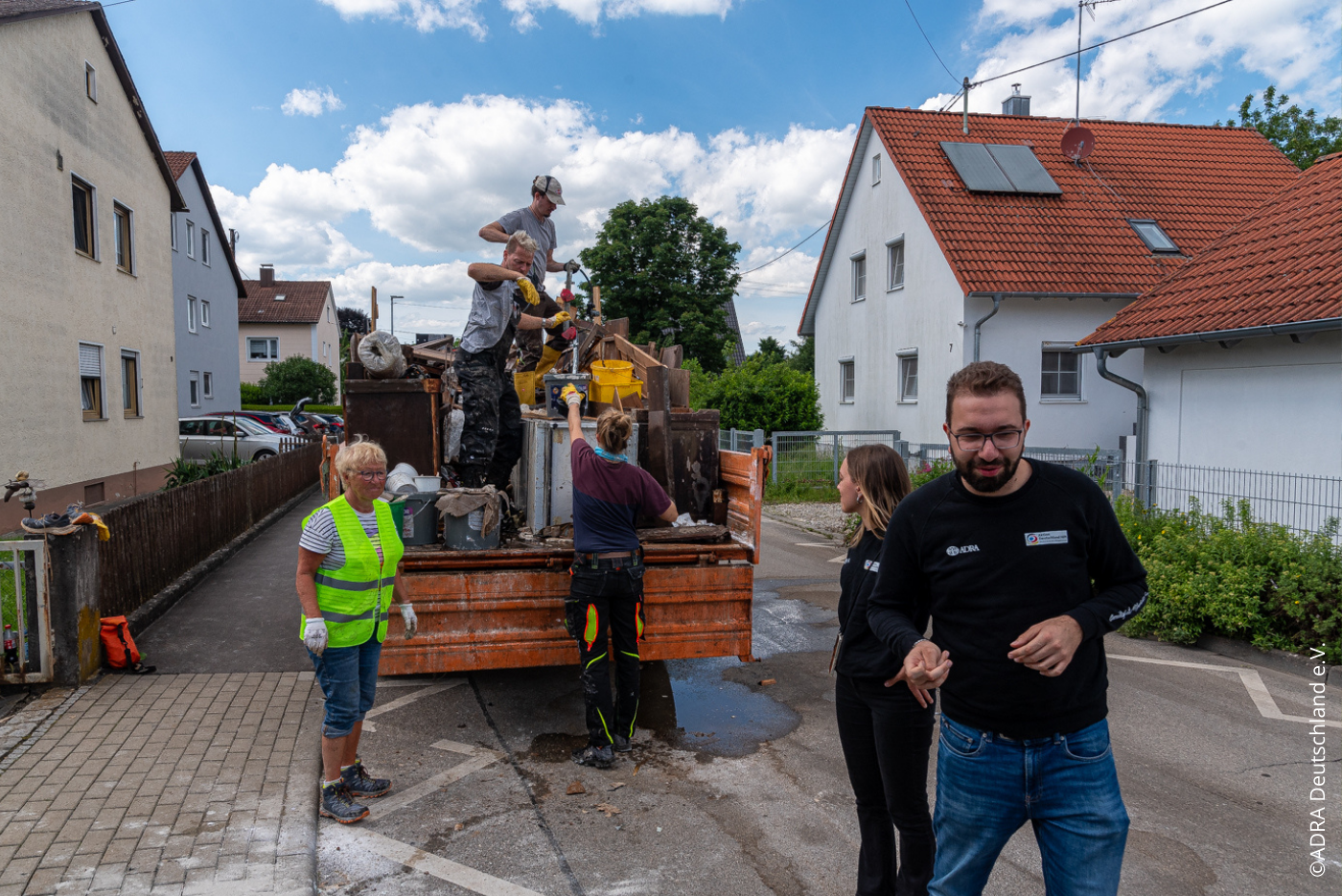 ADRA-Team koordiniert mit Freiwilligen die Entsorgung von beschädigten Haushaltsgegenständen nach der Flut.