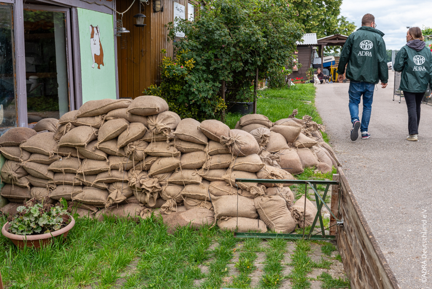 Ein großer Stapel Sandsäcke schützt ein Gebäude vor Hochwasser.