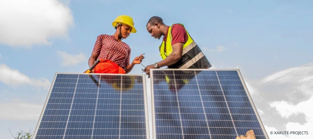 Zwei Fachkräfte installieren Solarmodule in Tansania und fördern durch grüne Technologien saubere Energie und nachhaltige Lebensgrundlagen.