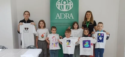 Kinder zeigen stolz bemalte T-Shirts in einem ADRA-Integrationsworkshop in Moldawien
