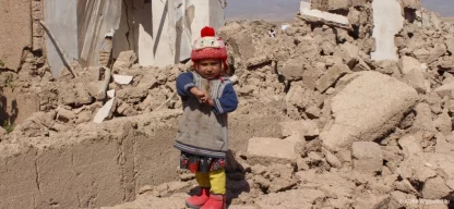 Kleines Kind steht in den Trümmern eines eingestürzten Hauses nach dem Erdbeben in Afghanistan, Symbolfoto für die Katastrophe