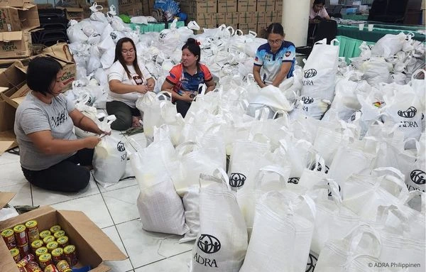 Mitarbeitende von ADRA bereiten in einer Sammelstelle auf den Philippinen Hilfsgüter und Lebensmittelpakete für den Taifun-Einsatz vor