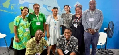 Gruppenfoto von Vertreterinnen und Vertretern der ADRA-Delegation aus dem Pazifik und Brasilien während der COP30 in Belém. Die Gruppe steht vor einer Weltkarte.