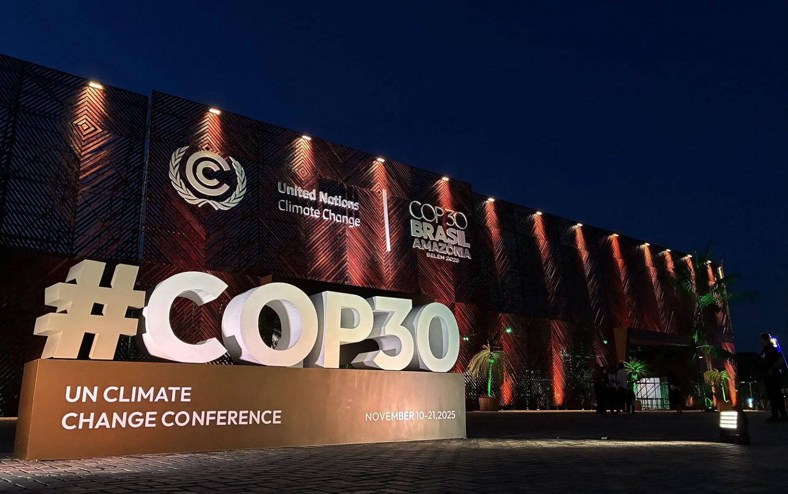 Beleuchtetes “#COP30”-Sign vor dem UN-Klimakonferenzgebäude bei Nacht