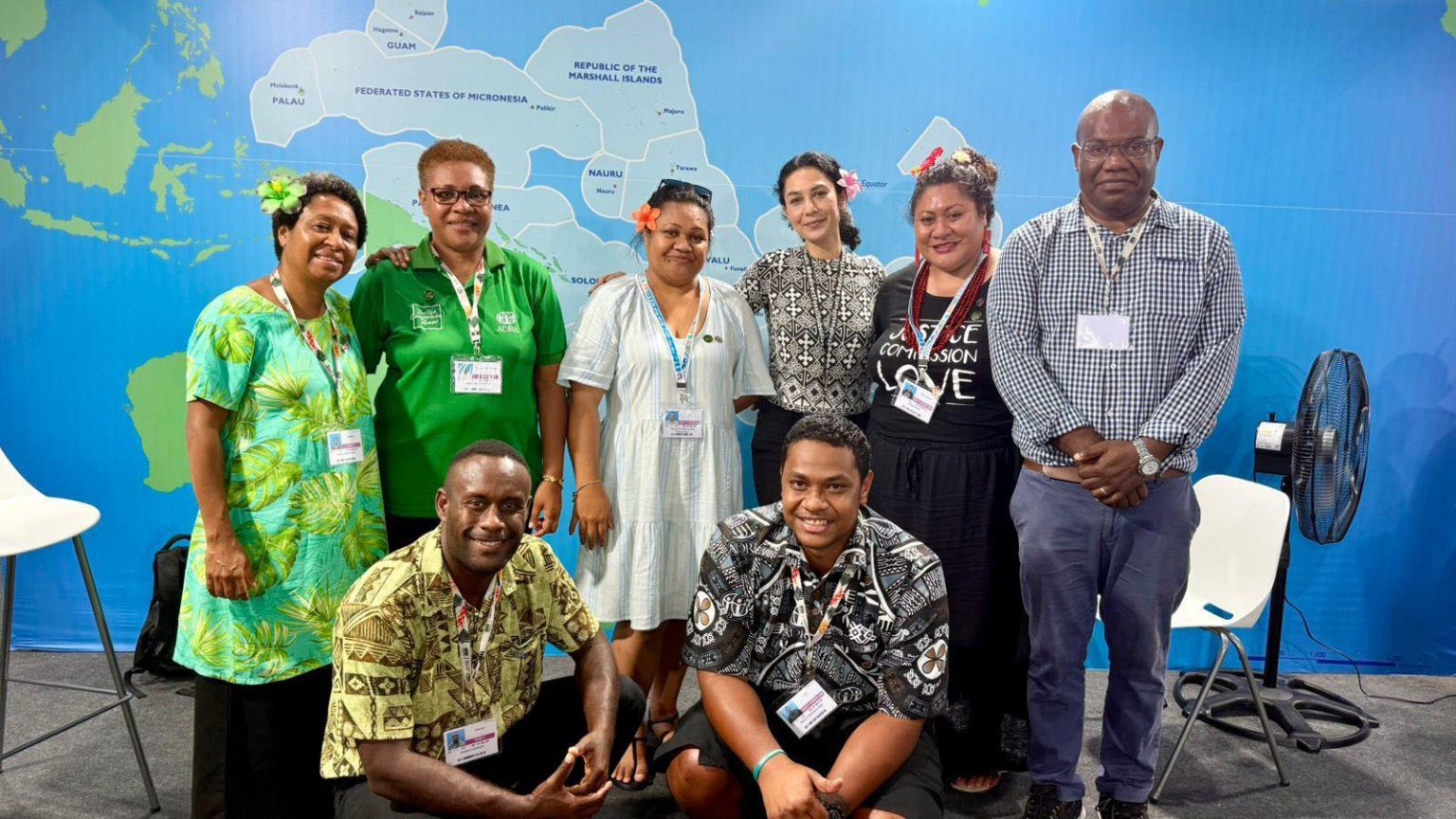 Gruppenfoto von Vertreterinnen und Vertretern der ADRA-Delegation aus dem Pazifik und Brasilien während der COP30 in Belém. Die Gruppe steht vor einer Weltkarte.