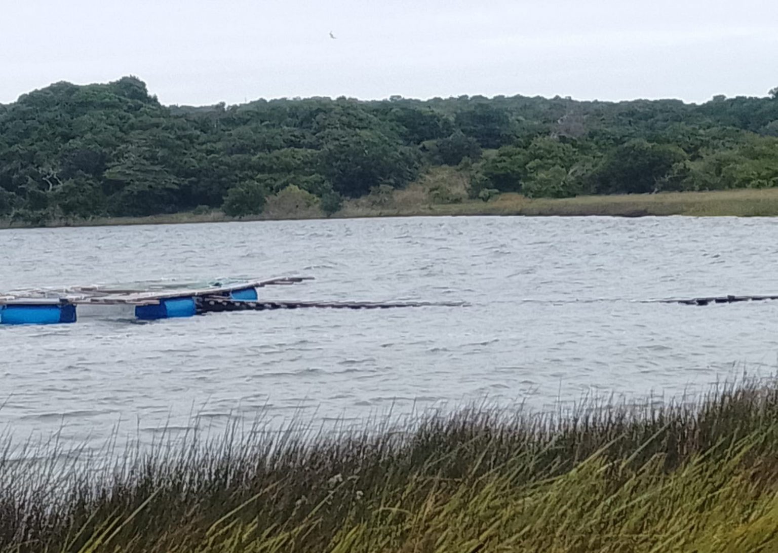 Überflutetes Gewässer mit beschädigten Stegen und Infrastruktur nach schweren Unwettern in Mosambik.