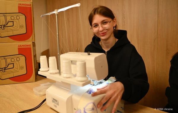 Schülerin sammelt praktische Erfahrungen an einer Nähmaschine im Berufsorientierungsprogramm von ADRA in der Ukraine.