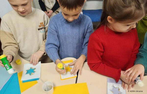 Kinder basteln Sterne aus Papier und Glitzer in einer Schule in der Westukraine im Rahmen des ADRA-Bildungsprojekts.