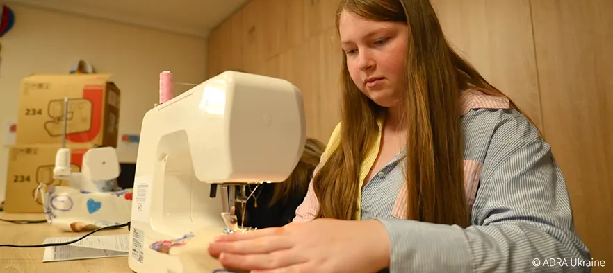 ugendliche näht an einer Nähmaschine in einer Schulwerkstatt in der Westukraine im Rahmen des von ADRA unterstützten Bildungsprojekts.