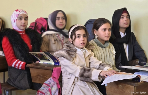 Schülerinnen sitzen nach der Renovierung ihrer Schule durch ADRA wieder im Unterricht in einem Klassenzimmer in Syrien.